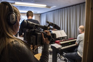 Martine Leine Rafteseth filmar bandøvinga i musikkbingen der bandet er i full gong med øvinga. Foto: Malin Nordby Kvamme